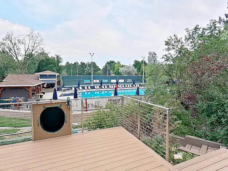 Raised Deck, with Slide to the grassy backyard, with community pool directly behind the property