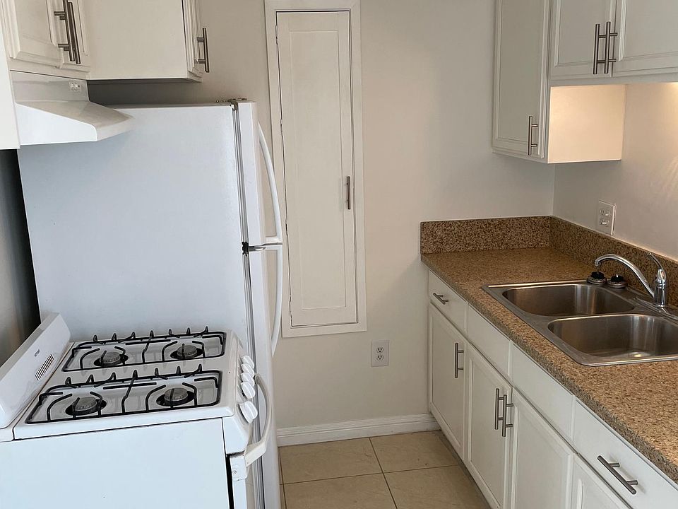 Photo of the galley kitchen with gas range and refrigerator.