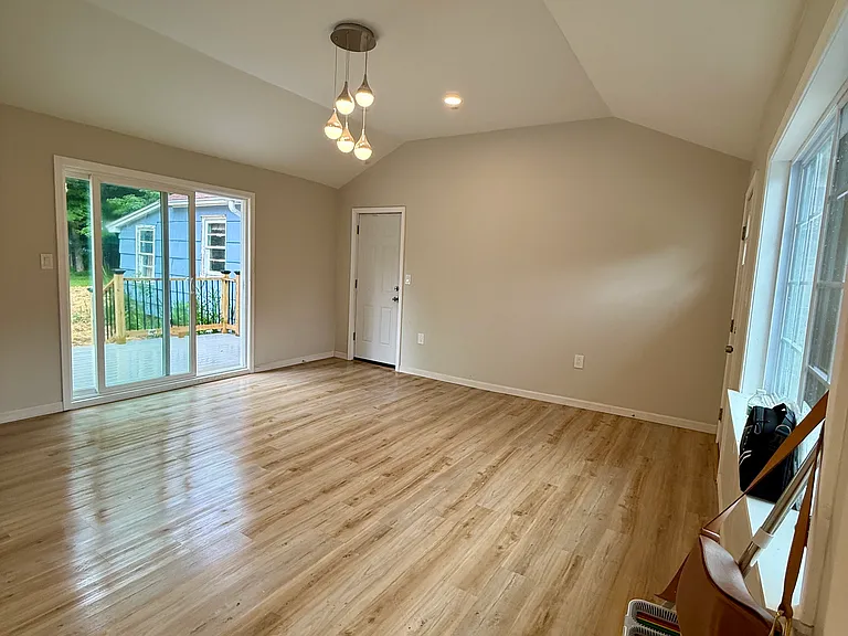 big bright sunroom leading to deck and large private backyard