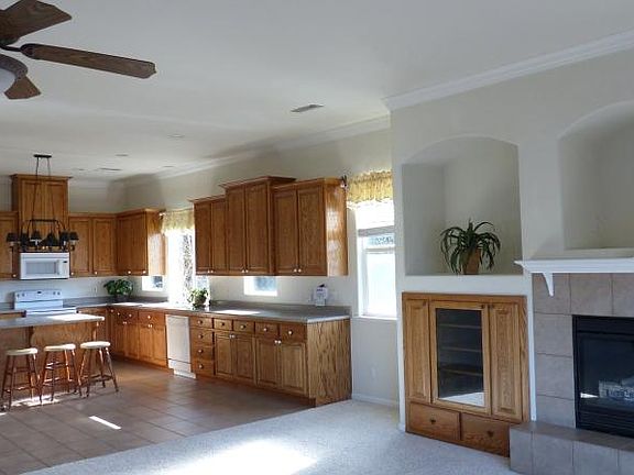 Cheerful kitchen with electrical stove, Refrigerator, Isle counter and chairs, plus storage for pantry.