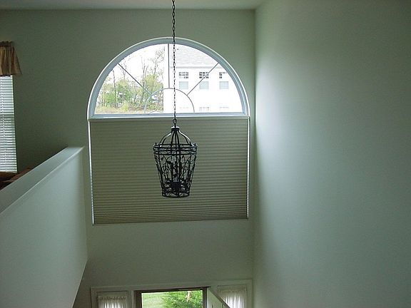 Large arched window has electric blind.