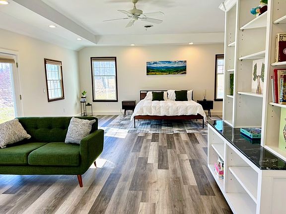 master bedroom w/ king bed, large en-suite bathroom, & sitting/TV area