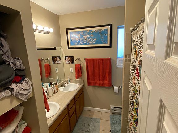 Master bathroom with dual vanity, shower/tub and linen shelving