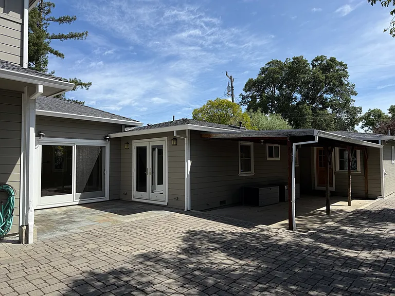 Side of house with patio and some storage boxes