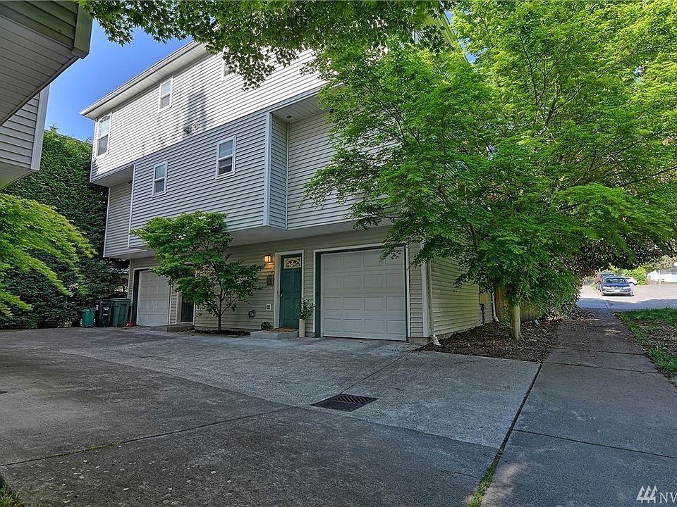Exterior of the home on the right.  Attached one car garage. Paved street & sidewalk. 