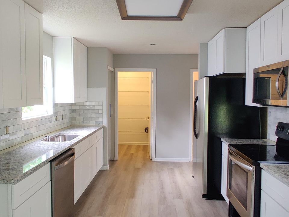 Newly renovated kitchen with new cabinets, granite countertops, and backsplash.