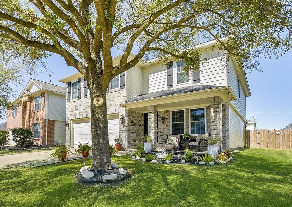 Beautiful home with front porch and mature tree.