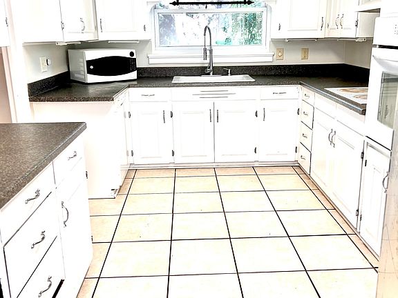 Large kitchen with flat top stove and stainless steel fridge