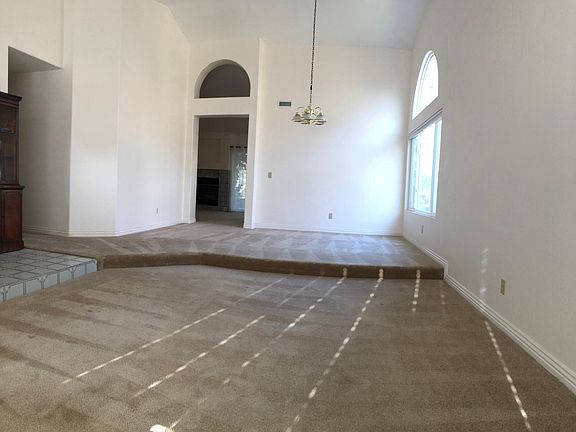Sunken living room next to dining room area. Kitchen and family room with fireplace beyond.