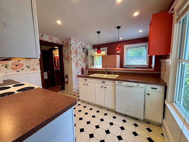 View of kitchen from dining room. New frig, electric stove and dishwasher