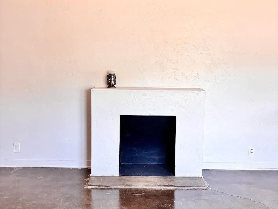 Concrete floors in living room with faux fireplace