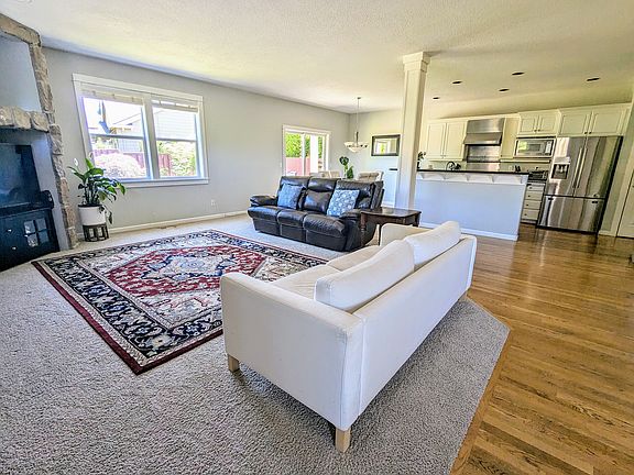 Living room with an open floor plan overlooking the kitchen and dining area