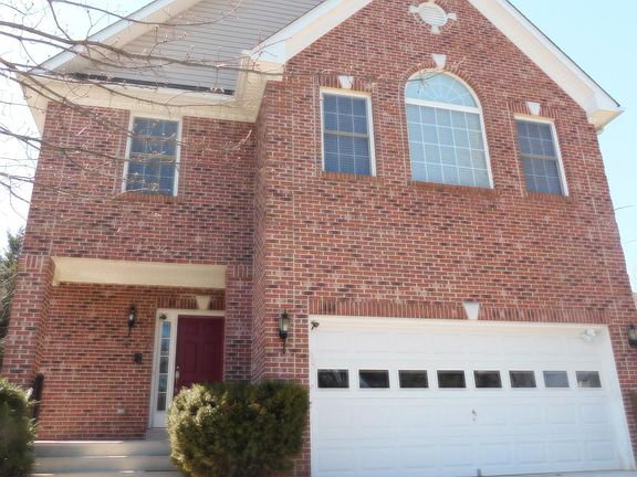 Front of house with covered porch and two-car driveway