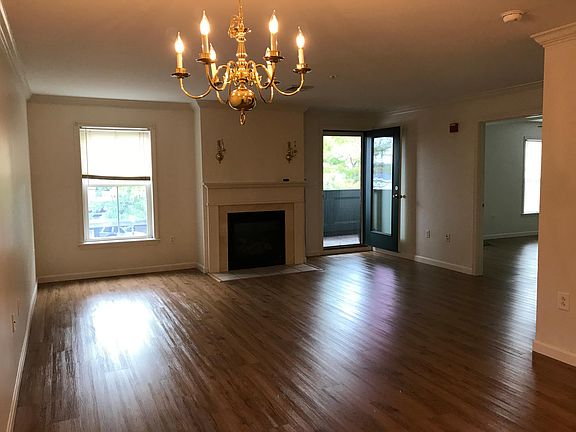 Open space living room with gas fireplace and access to a private balcony.