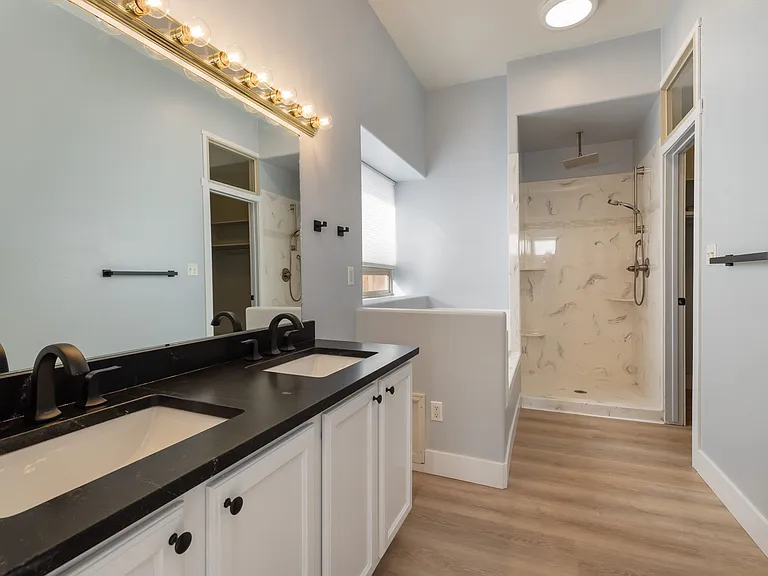 Granite countertops, jetted tub, shower and walk-in closet on right