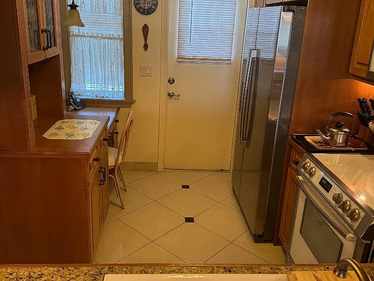 view through kitchen from pass-through to window and kitchen door onto exterior walkway.
