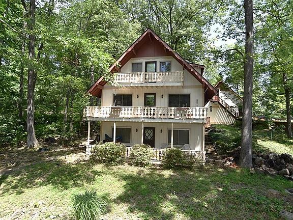 Front of Property Facing Lake Sweetwater and Quiet Cove, featuring 3 walk out decks and trapezoid lot shape, including wooded acreage.