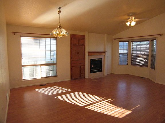 Vaulted living/dining area has bay window and ceiling fan
