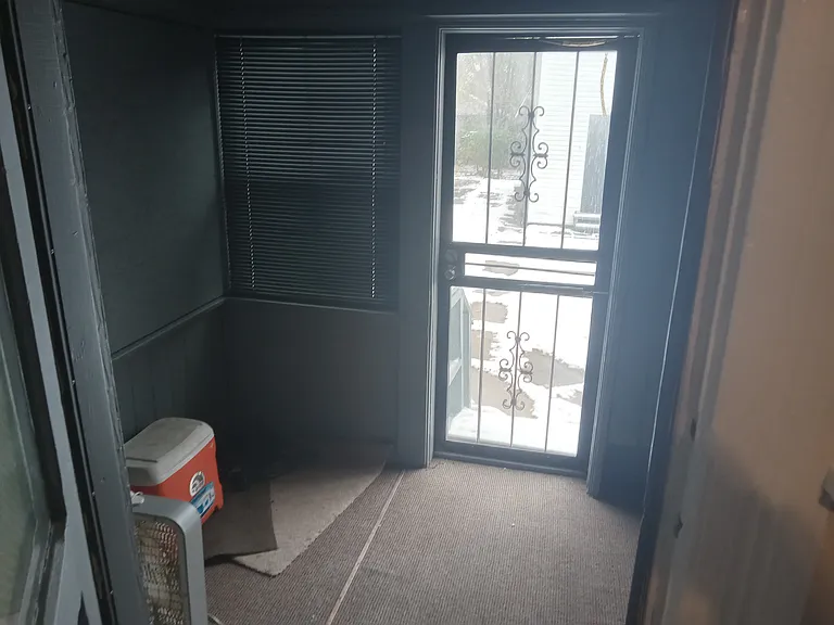 Back door open looking onto enclosed back porch off of Kitchen