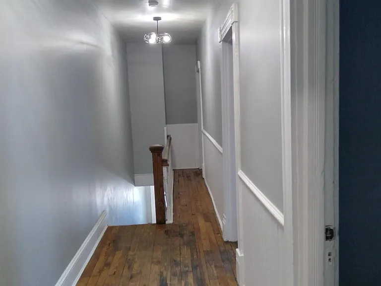 Upstairs hall. There are 3 bedrooms on right side. Bathroom at opposite end of hall (behind where photographer is standing).
