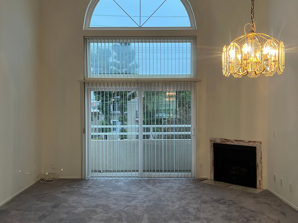 2-story living room with patio view + fireplace