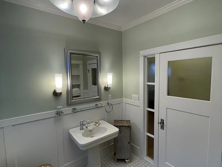Pedestal sink and modern lighting.