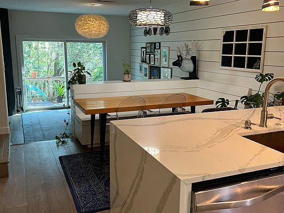 View after walking in the front door. Quartz countertop with waterfall, dining with built in banquette.
