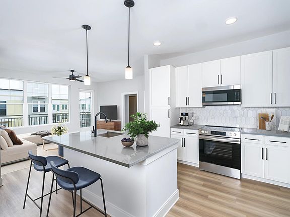 Our alternative option features fresh white cabinets with black hardware, gray quartz counters, and vertical, precious Calacatta Florida tile.