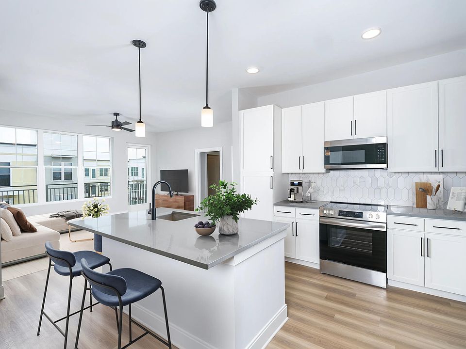 Our alternative option features fresh white cabinets with black hardware, gray quartz counters, and vertical, precious Calacatta Florida tile.