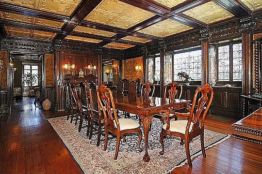 The extraordinary Dining Room features elegant carved moldings, a custom ar