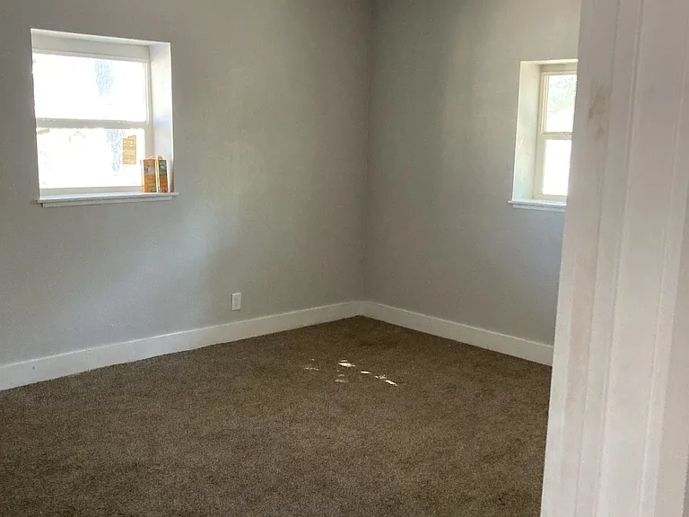 Bedroom 1 with its own closet, ceiling fan, and carpet.
