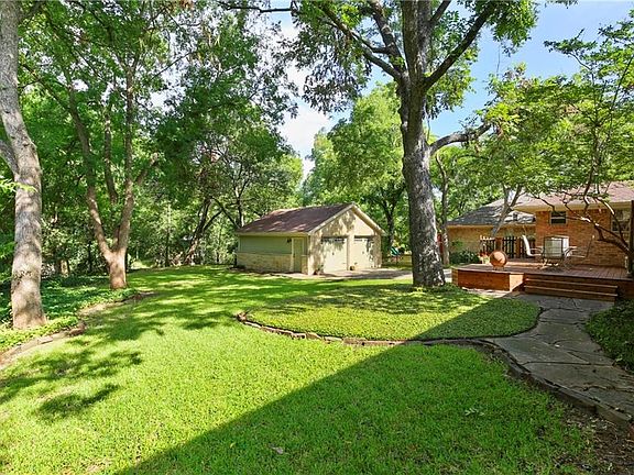 Lush creek lot in West Richardson - Featuring a large yard, gorgeous landscaping, a stunning Austin stone garage, and a new deck. Walk to the neighborhood parks for tennis, swimming and new playgrounds!