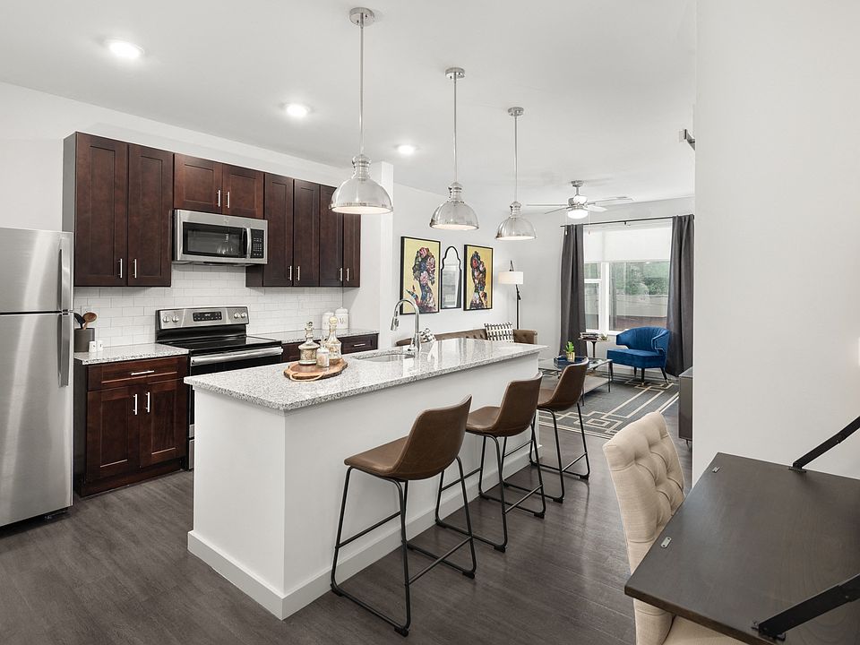 Kitchen with Dark Wood Cabinets, Granite-Style Countertops, Island, and Stainless Steel Appliances