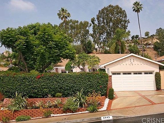 Front of home with hedge for privacy and drought tolerant gardens