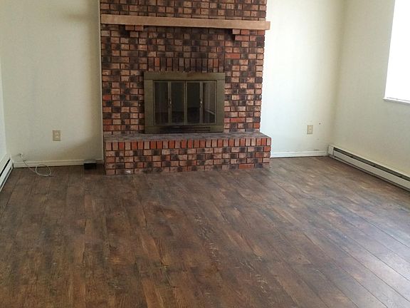 Cozy living room with hardwood floor and a brick fireplace f
