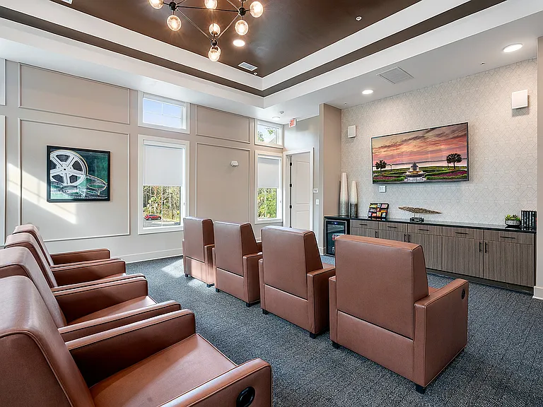 Elegant and cozy apartment media room with plush seating, contemporary lighting, and a large wall-mounted TV, perfect for entertainment.