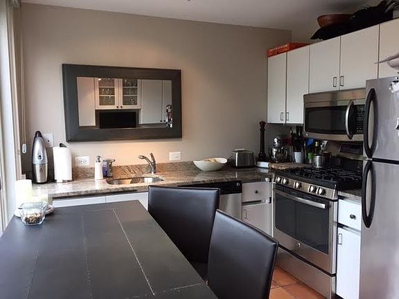 Eat in kitchen with granite countertops and stainless steel appliances.