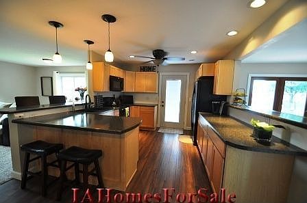 Kitchen with maple cabinets and breakfast bar seating for at least 4. Beautiful rustic laminate flooring throughout kitchen and entryway.