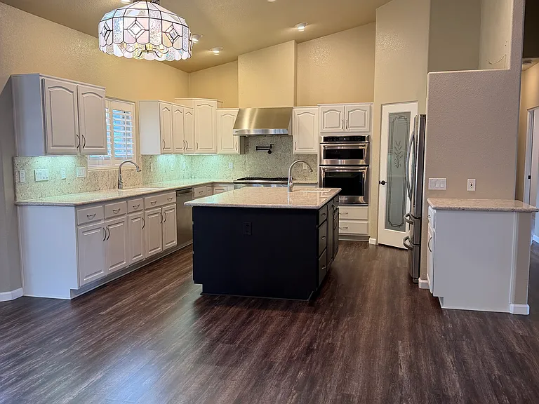 Large kitchen with lots of storage, island, and pantry flows seamlessly into open concept living space