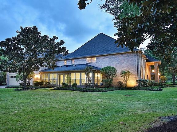 MAGNIFICENT MAGNOLIA: The wall of windows in the sunroom overlooks the expansive side yard which is anchored by a beautiful magnolia tree. In a few months, it will be laden with white, fragrant blooms.
