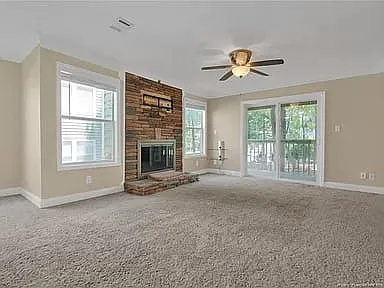 Cozy livingroom with brick fascade fireplace and screened in sliding door to balcony.