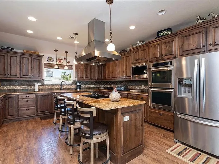 Beautiful island kitchen with endless custom cabinets, granite countertops, and stainless steel appliances