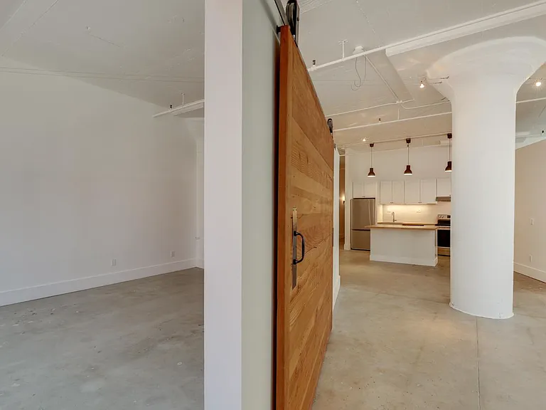 Barndoor seperating living area and Primary Bedroom (with closet)