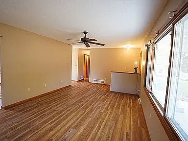 Living room with nice size front windows and ceiling fan