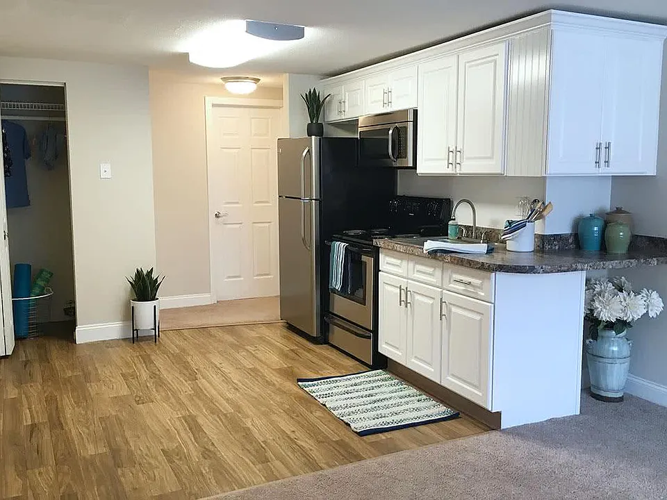 Newly remodeled kitchen in our Sunrise floor plan featuring granite-style countertops, wood-style flooring, and ample cabinet space.