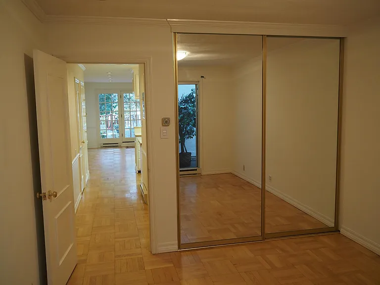 Bedroom and closet space behind mirrored sliding doors. Hallway to living room to left. Private patio beyond French doors.
Parquet hardwood floors. Recessed lighting.