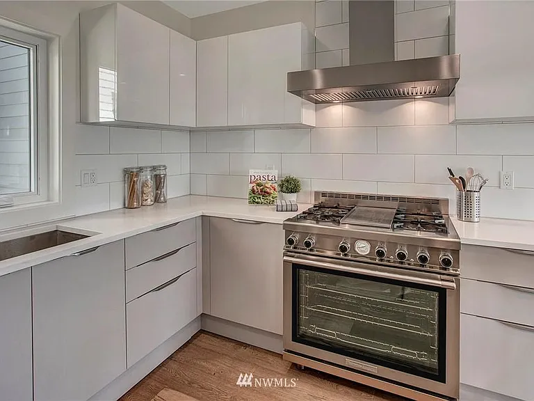 The sleek high-end kitchen features chef's grade stainless steel appliances, marble casual counters, plentiful cabinets and a wine fridge.