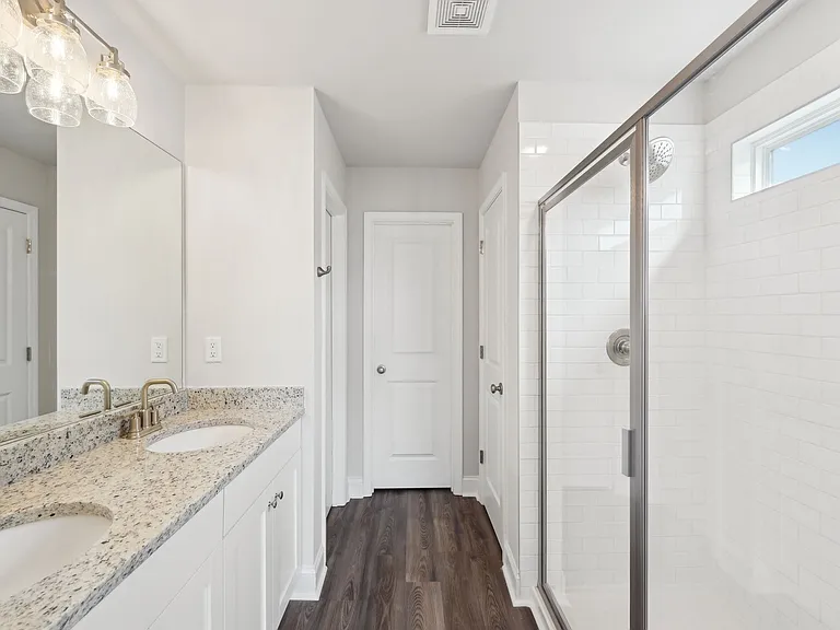 Primary bathroom with double vanity, and walk-in shower.