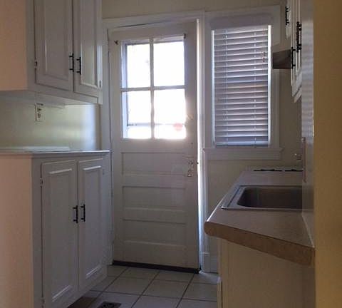 Kitchen with back door opening onto a deck and to backyard and parking.