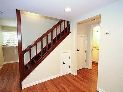 Entrance to downstairs bath, with washer/dryer hook-ups, hall to kitchen and stairs to second floor.
